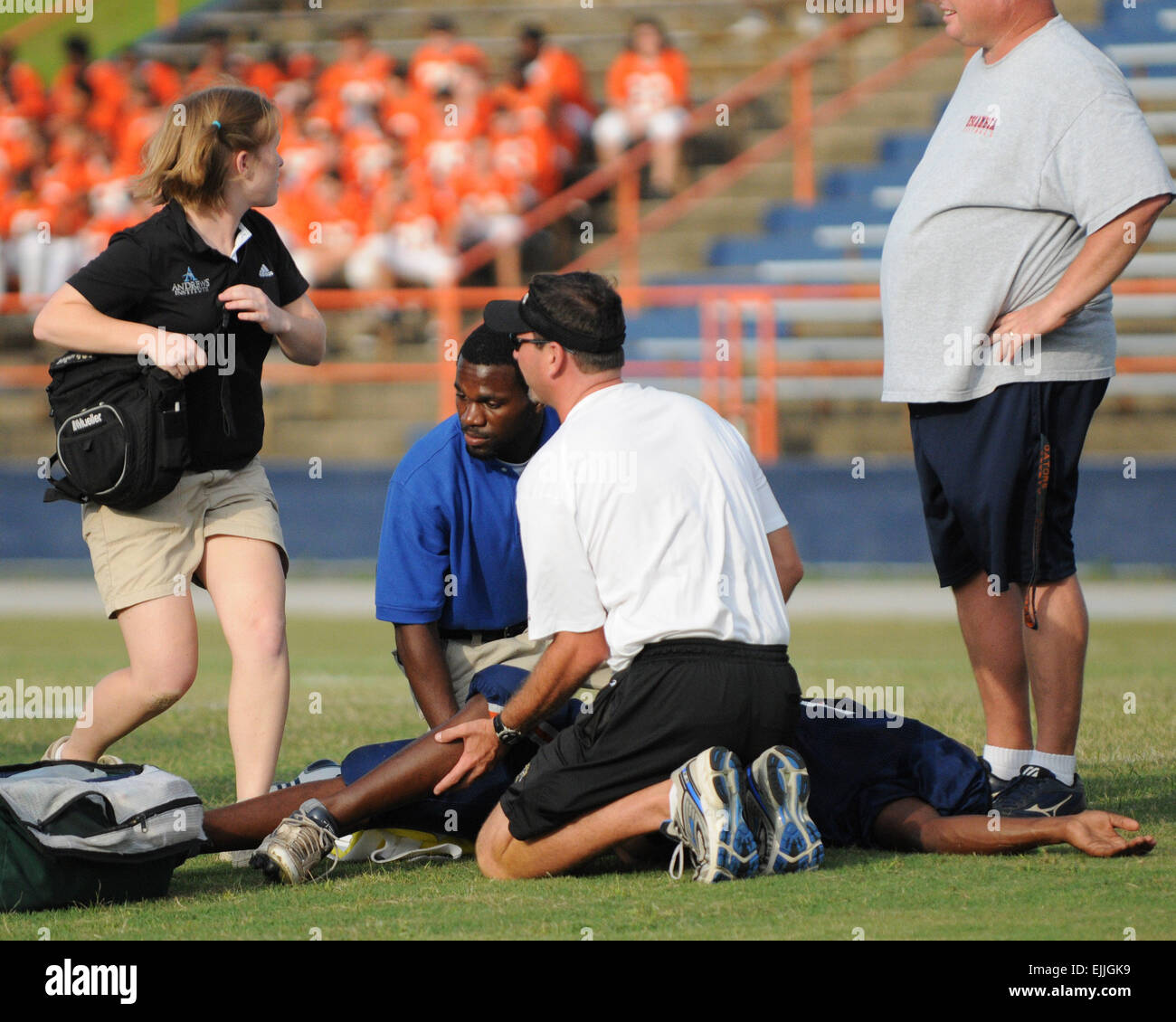 Medical personnel tend to injured football player on the field Stock Photo