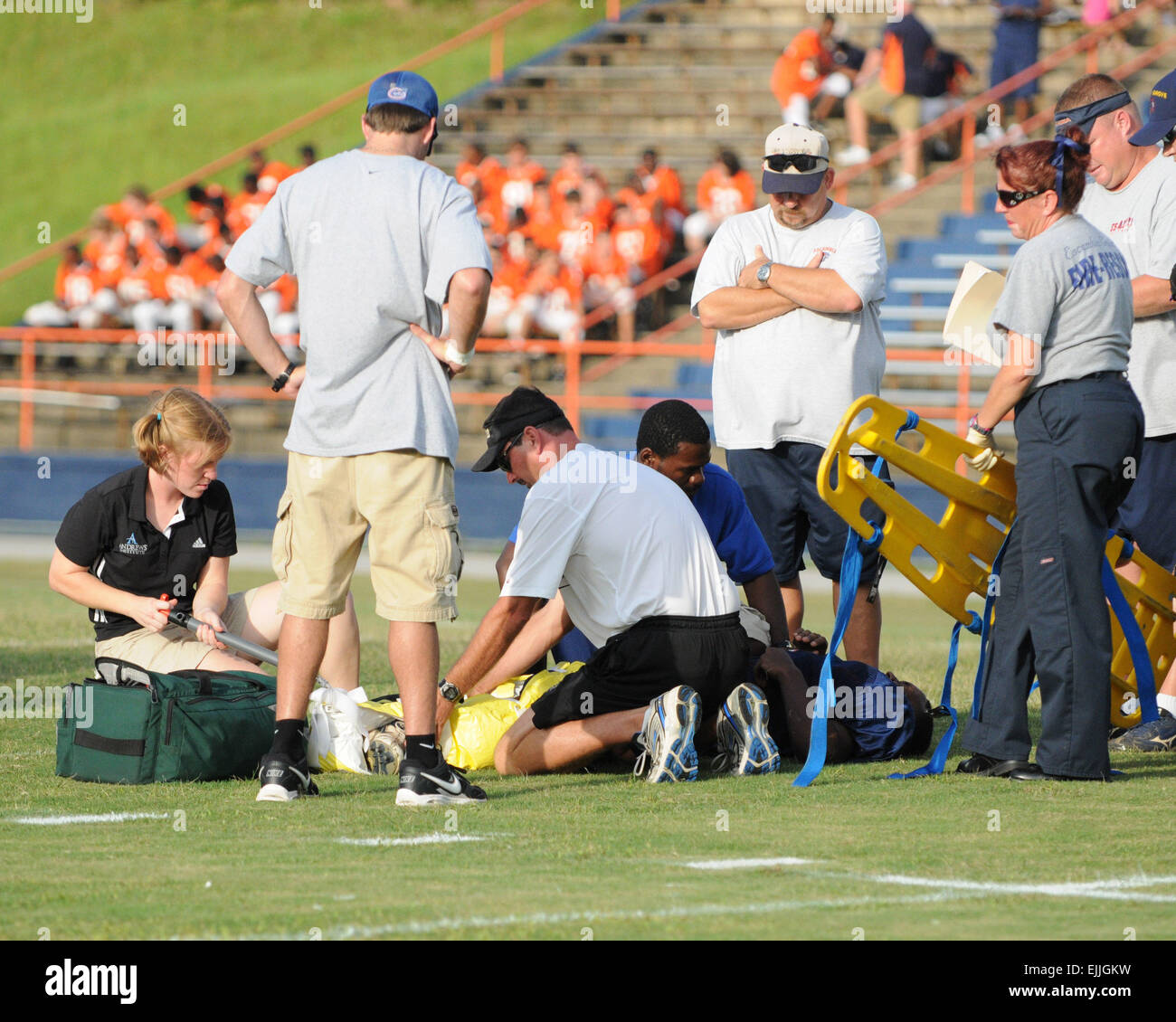 Medical personnel tend to injured football player on the field Stock Photo