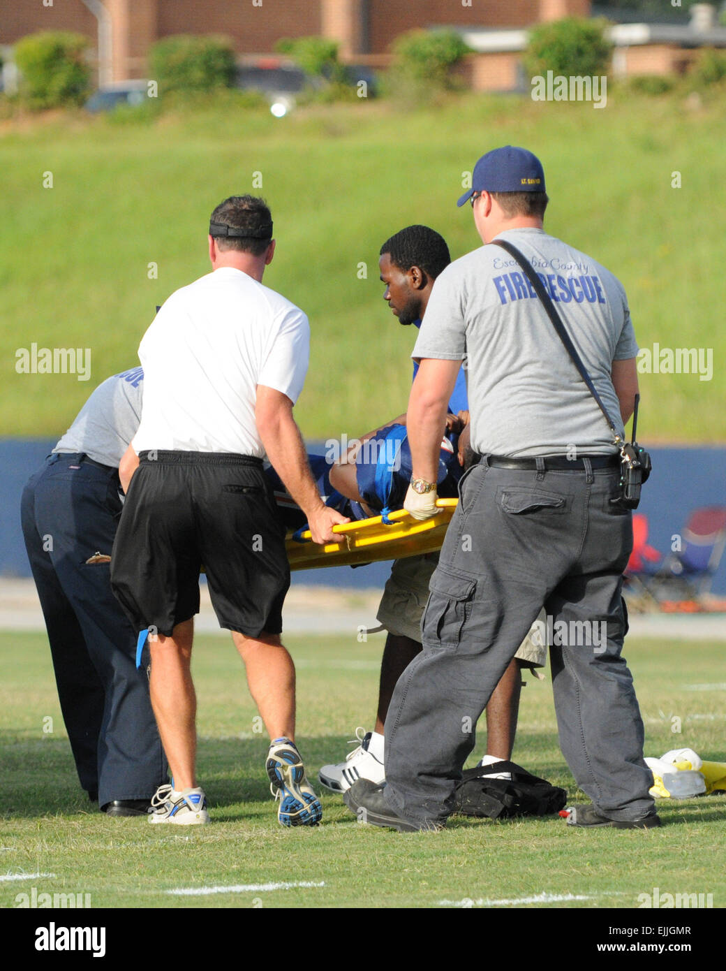 Medical personnel transport injured football player off the field Stock Photo