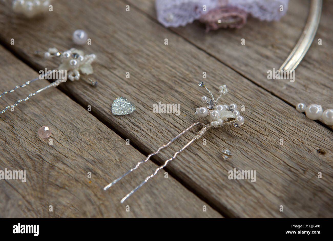 Silver hair pieces and pins for a bride with pearls over old wooden table Stock Photo