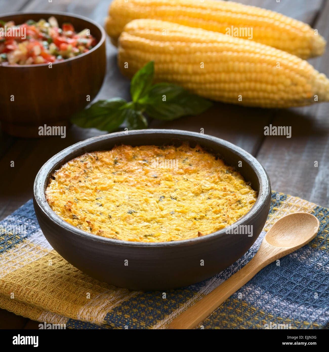 Bowl of traditional Chilean corn pie called Pastel de Choclo served with Pebre sauce in the back, photographed on cloth Stock Photo