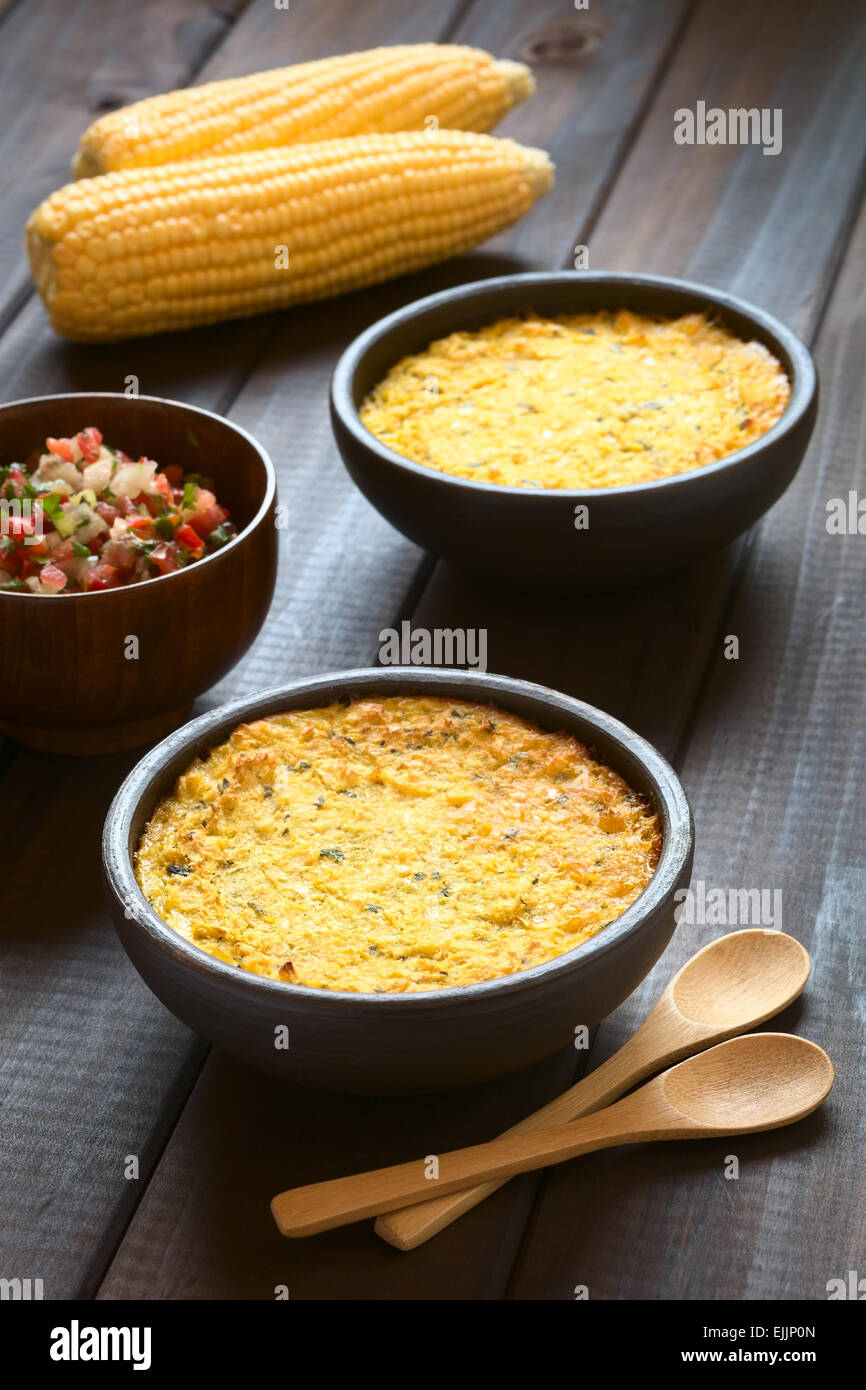 Bowls of traditional Chilean corn pie called Pastel de Choclo served with Pebre sauce in the back, photographed on dark wood Stock Photo