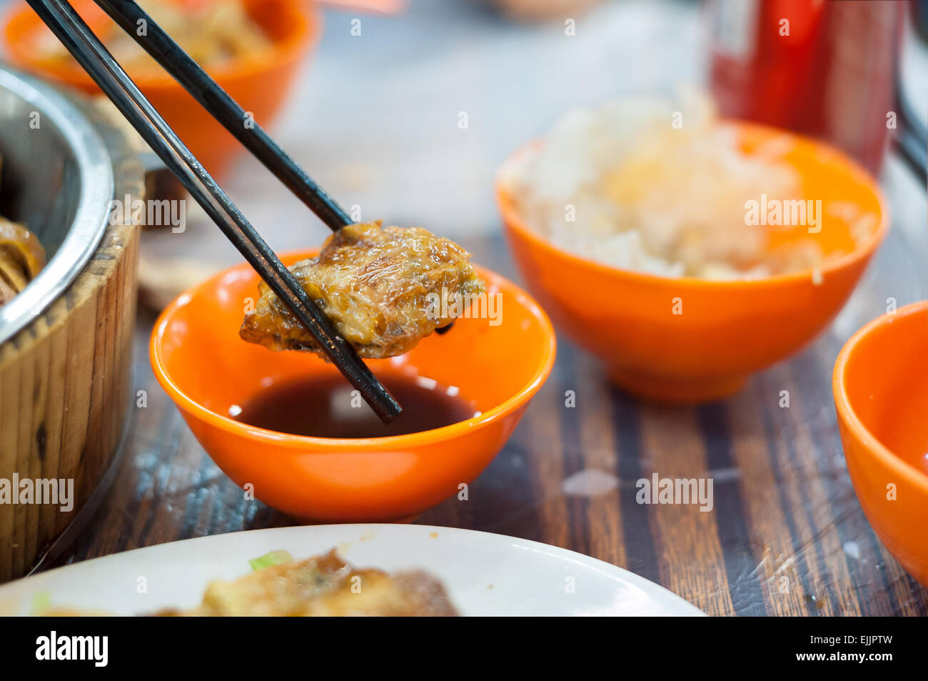 Fried spring roll held by chopsticks at a Hong Kong dai pai dong Stock Photo