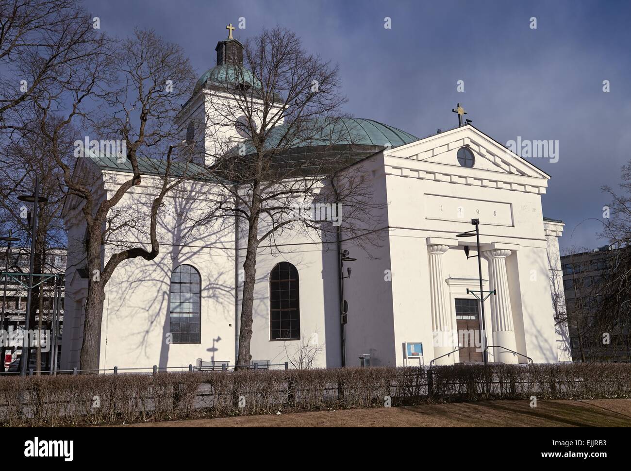 Small church of Hameenlinna in Finland. Early spring sun shining straight to the white walls of the building. Stock Photo