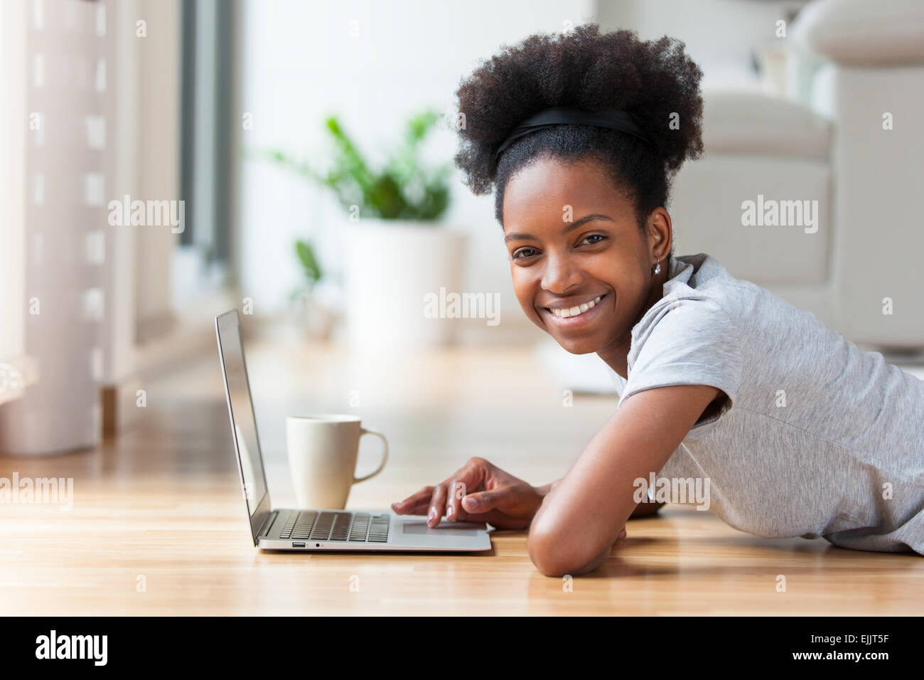 African American woman using a laptop in her living room - Black people ...