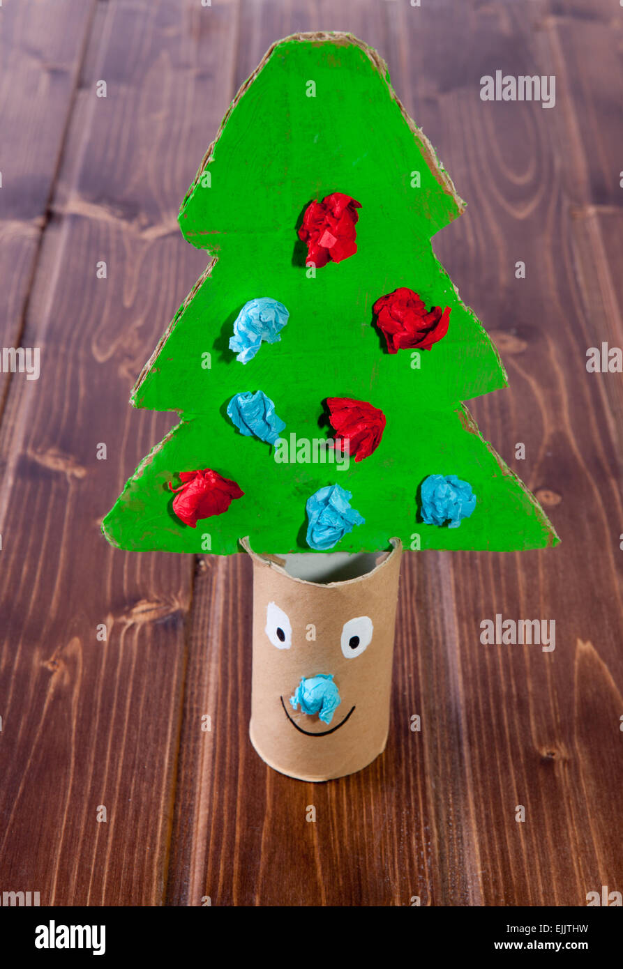 Cardboard Christmas tree made with recycled material over wooden surface Stock Photo