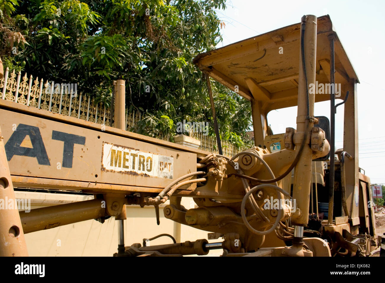 A Caterpillar motor grader is parked on a city street in Kampong Cham, Cambodia. Stock Photo