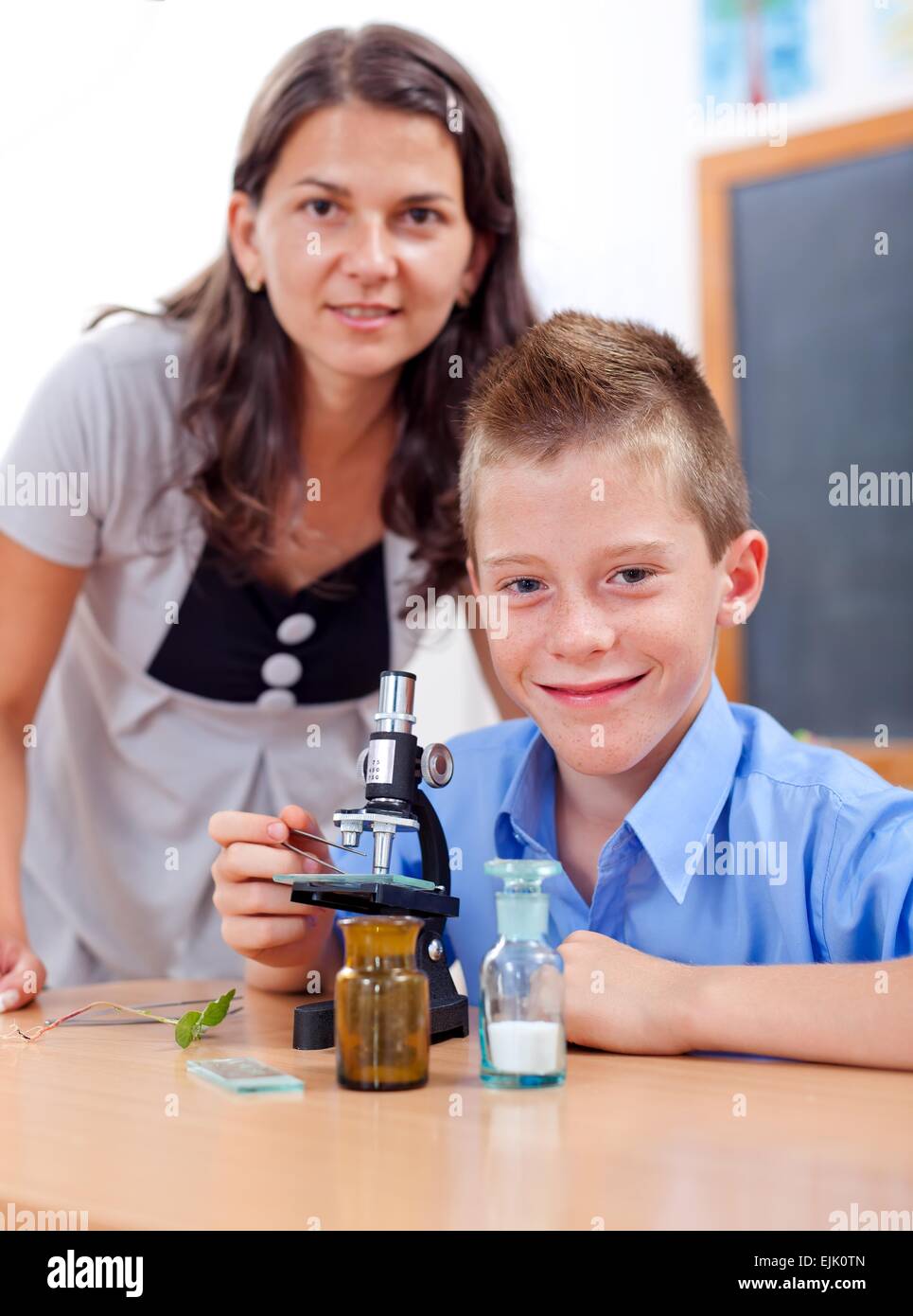 Wise boy with microscope and the biology teacher Stock Photo