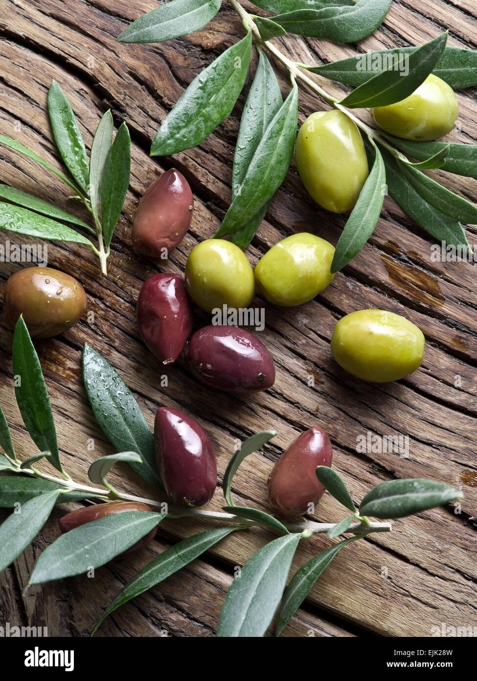 Olives and olive twigs on wooden table. Stock Photo