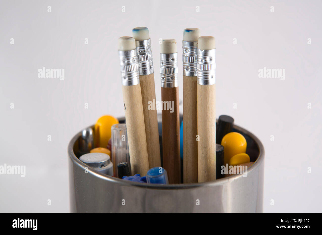 Tin shinny metal pencil pot with five pencils in the middle Stock Photo