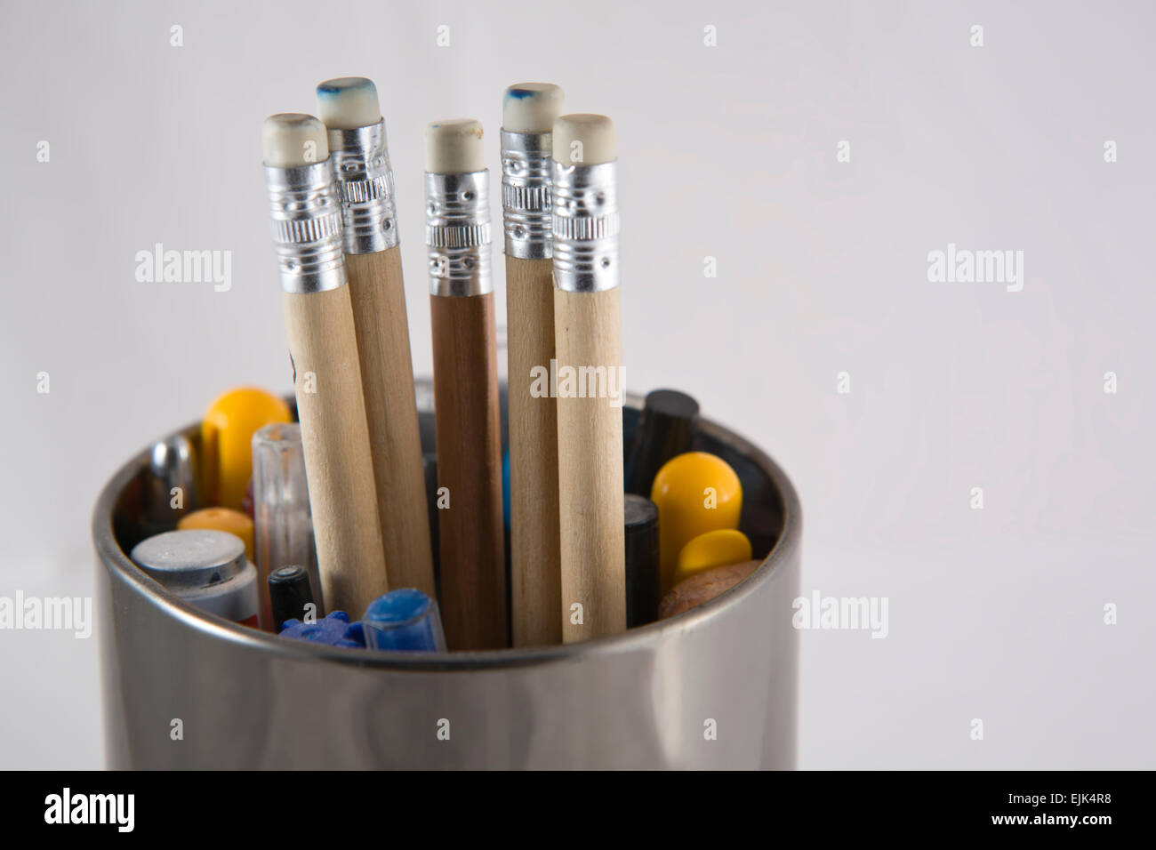 Tin shinny metal pencil pot with five pencils in the middle Stock Photo