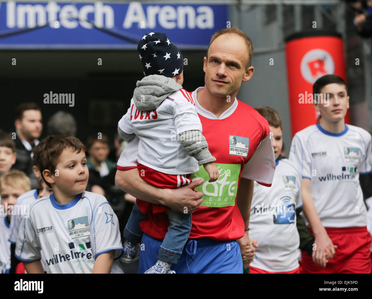 Hamburg, Germany. 28th Mar, 2015. Former HSV soccer player David Jarolim enters the arena with his children for his farewell match, HSV-Allstar-Team vs Jarolim-Dream-Team, at Imtech Arena in Hamburg, Germany, 28 March 2015. PHOTO: AXEL HEIMKEN/dpa/Alamy Live News Stock Photo