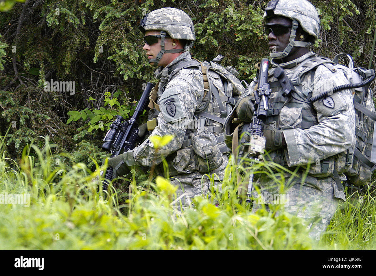 Army Pfc. Travis Watson, left, and Spc. Alfred Angelo, A Troop, 1st Squadron Airborne, 40th Cavalry Regiment, move to their next positions as the unit conducts a section level dismounted livefire at the Infantry Platoon Battle Course, June 19, 2013. Soldiers traversed the 250-meter course in teams, reacting to enemy contact, conducting hasty attacks using bounding overwatch techniques to reach their objectives, and using proper procedures for reporting casualties and resupply needs. Stock Photo