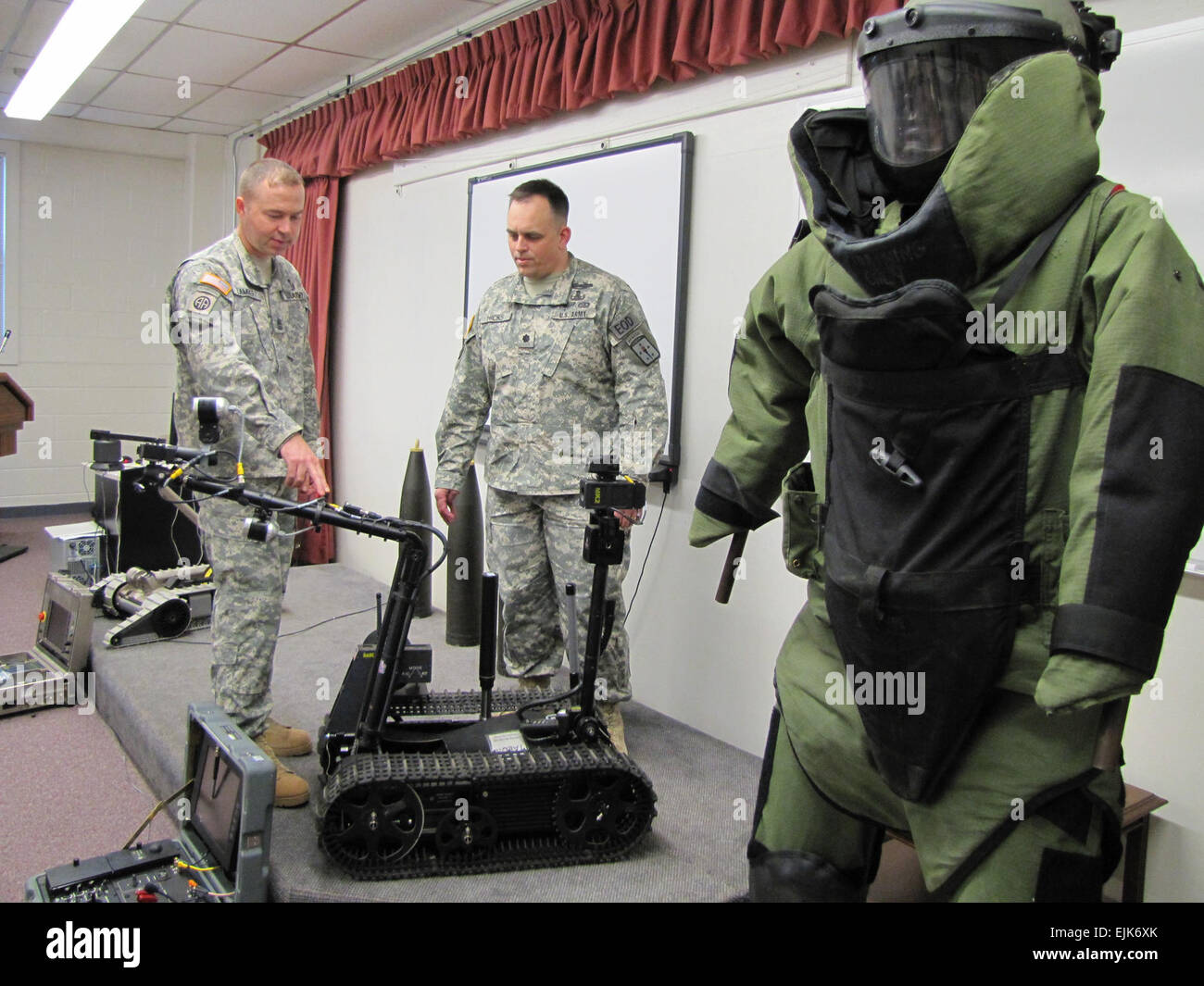 Sgt. Maj. James Lambert and Lt. Col. Michael &quot;Greg&quot; Hicks, both of the Explosive Ordnance Disposal/Munitions Training Department at the Ordnance Munitions and Electronics Maintenance School, look over equipment similar to what was used to tell the story of EOD Soldiers in Iraq in the Academy Award-winning movie &quot;The Hurt Locker.&quot; The Talon robot and EOD bomb suit play significant roles in the movie. Stock Photo