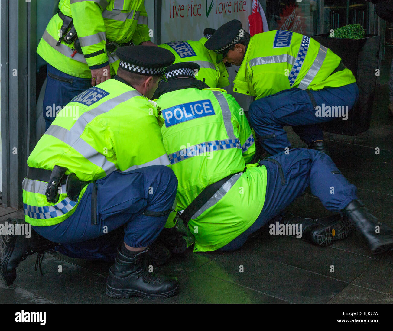 Manchester, UK 28th March, 2015. Protesters restrained after a confrontation with five arresting uniformed police officers, at the National Front & White Pride Demo in Piccadilly. Arrests were made as Far Right 'White Pride' group gathered in Manchester to stage a demonstration when about 50 members of the group waved flags and marched through Piccadilly Gardens. Anti-fascist campaigners staged a counter-demonstration and police line separated the two sides. Greater Manchester Police said two arrests were made, one for a breach of the peace. The second was also held for a public order offence. Stock Photo