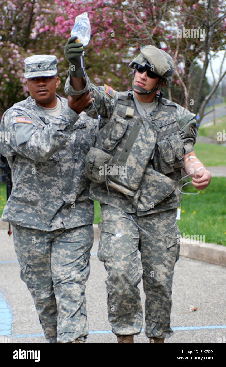 U.S. Army Spc. Peter Bishop assists Sgt. Luis S. Delgadillo, who is roleplaying as an open-chest wound victim, as they return from a convoy mission during mobilization training at Fort Dix, N.J., April 28, 2007. Bishop and Delgadillo are both assigned to the 302nd Mobile Public Affairs Detachment, Bell, Calif.  Pfc. Jennifer L. Sierra Stock Photo