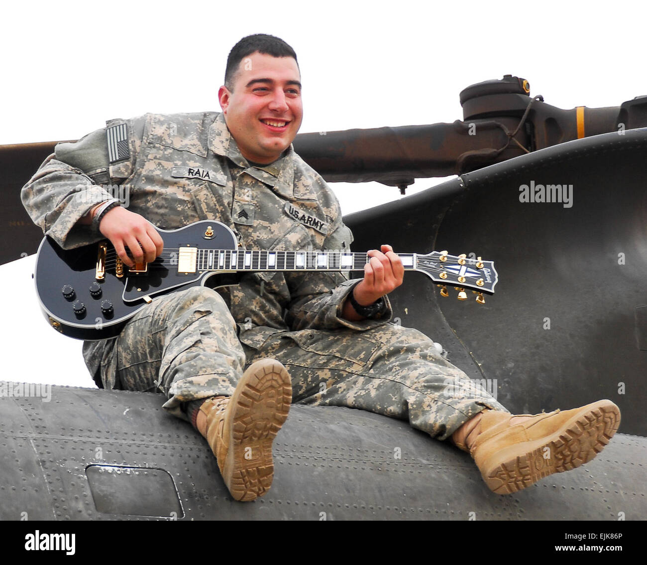 Sgt. Nicholas Raia of Altoona, Pa., strums his guitar on top of a CH-47 Chinook helicopter at Contingency Operating Base Adder, Iraq. Raia, who performs in the Pennsylvania National Guard's 28th Infantry Division Band, volunteered to deploy as a door gunner with the 28th Combat Aviation Brigade.         Guard Soldier trades guitar for gun  /-news/2009/10/30/29622-guard-soldier-trades-guitar-for-gun/ Stock Photo