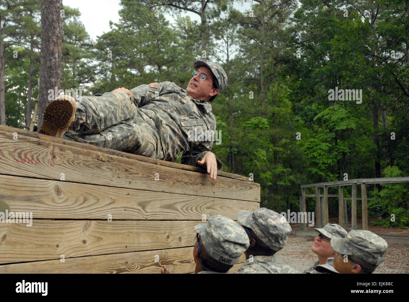 Pvt. Stephen Colbert rests atop one of the walls on the five-wall obstacle rather than aiding his fellow Soldiers who helped him reach the top.        Political humorist Colbert tackles Basic Combat Training  /-news/2009/05/08/20858-political-humorist-colbert-tackles-basic-combat-training/ Stock Photo