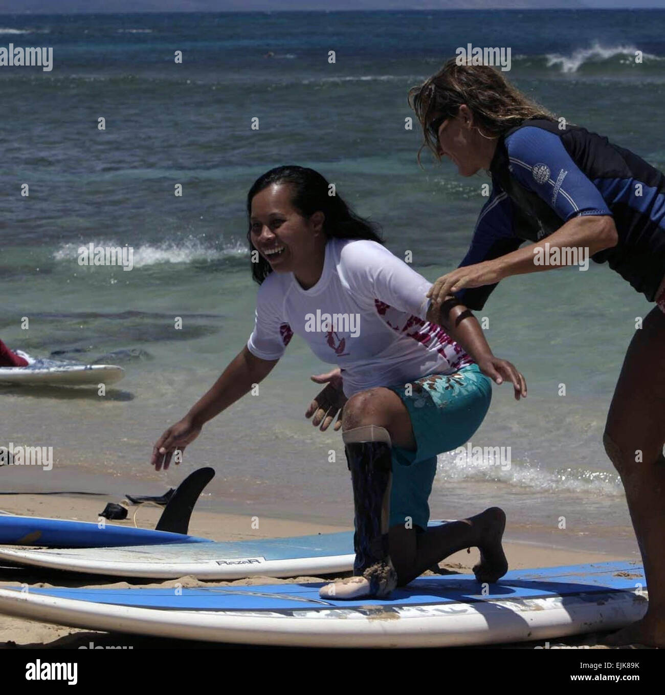 Molly Hayden; Staff Writer; U.S. Army Garrison; Hawaii; Public Affairs May 15, 2008  Sgt. Lilina Benning left, a Wounded Warrior, gets a surf lesson from Suzy Stewart at Kailua Beach on the island of Oahu, Hawaii. Community supporters helped spread some aloha to a group of 26 Wounded Warriors and Family members by providing services and resources for many outdoor activities, May 6-16. Afterwards, the Wounded Warriors, most of whom are amputees, returned to Brooke Army Medical Center, Fort Sam Houston, to continue recuperating. Stock Photo