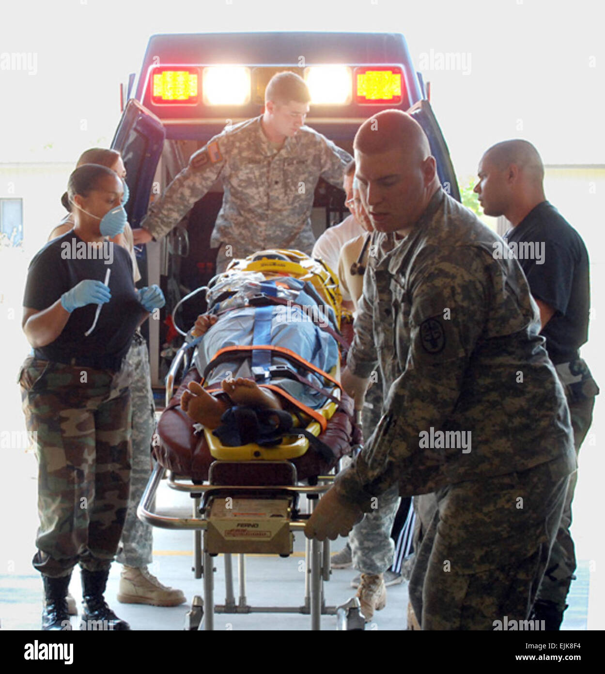 U.S. servicemembers from a medical element assigned to Joint Task Force - Bravo transition an accident victim from an ambulance to the medical element emergency room on Soto Cano Air Base, Honduras, Feb. 26, 2008. JTF-Bravo members assisted local medical personnel after a truck carrying about 30 people rolled over near Comayagua, Honduras.  Tech. Sgt. John Asselin Stock Photo