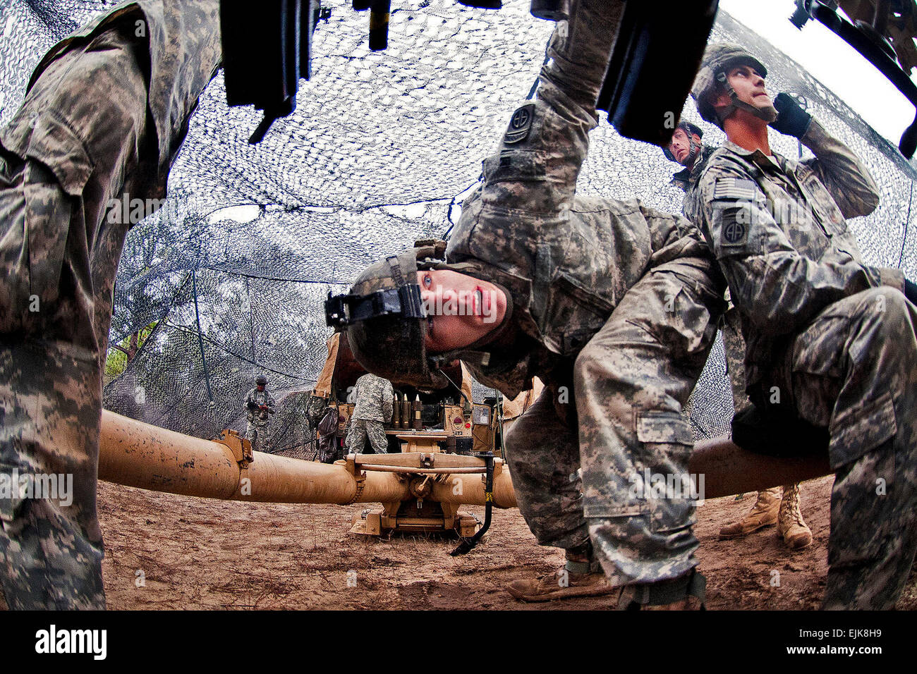 Spc. Michael Davis, center, checks the breech of an M119A2 105mm lightweight howitzer