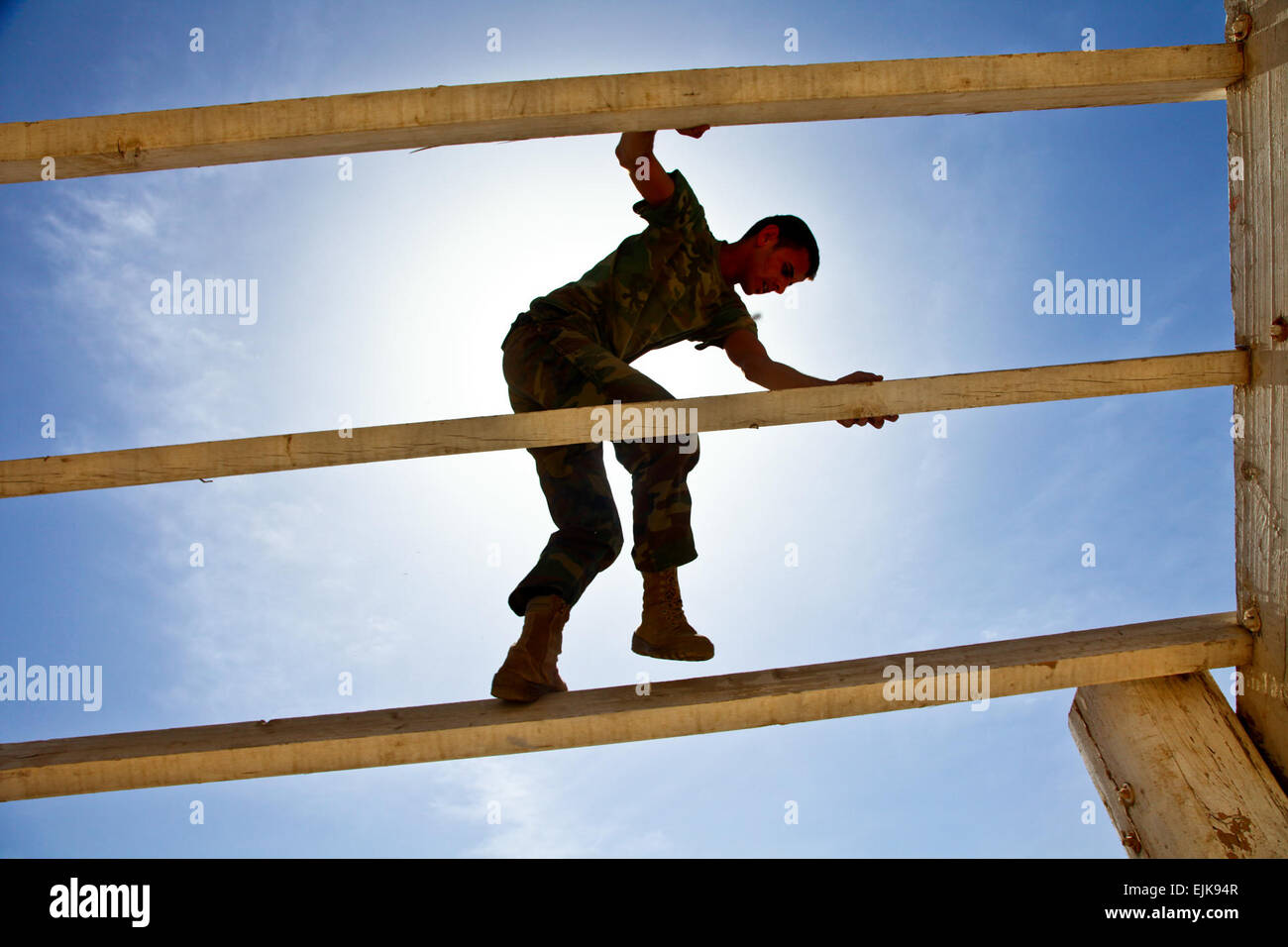An Iraqi border enforcement officer, Candidate 2nd Lt. Mustafa Khayon, climbs down an obstacle at a course at the Shaibah Training Center near Contingency Operating Base, Basra, Iraq, March 15, 2010. U.S. Soldiers also participated in the course.  Staff Sgt. Adelita Mead Stock Photo