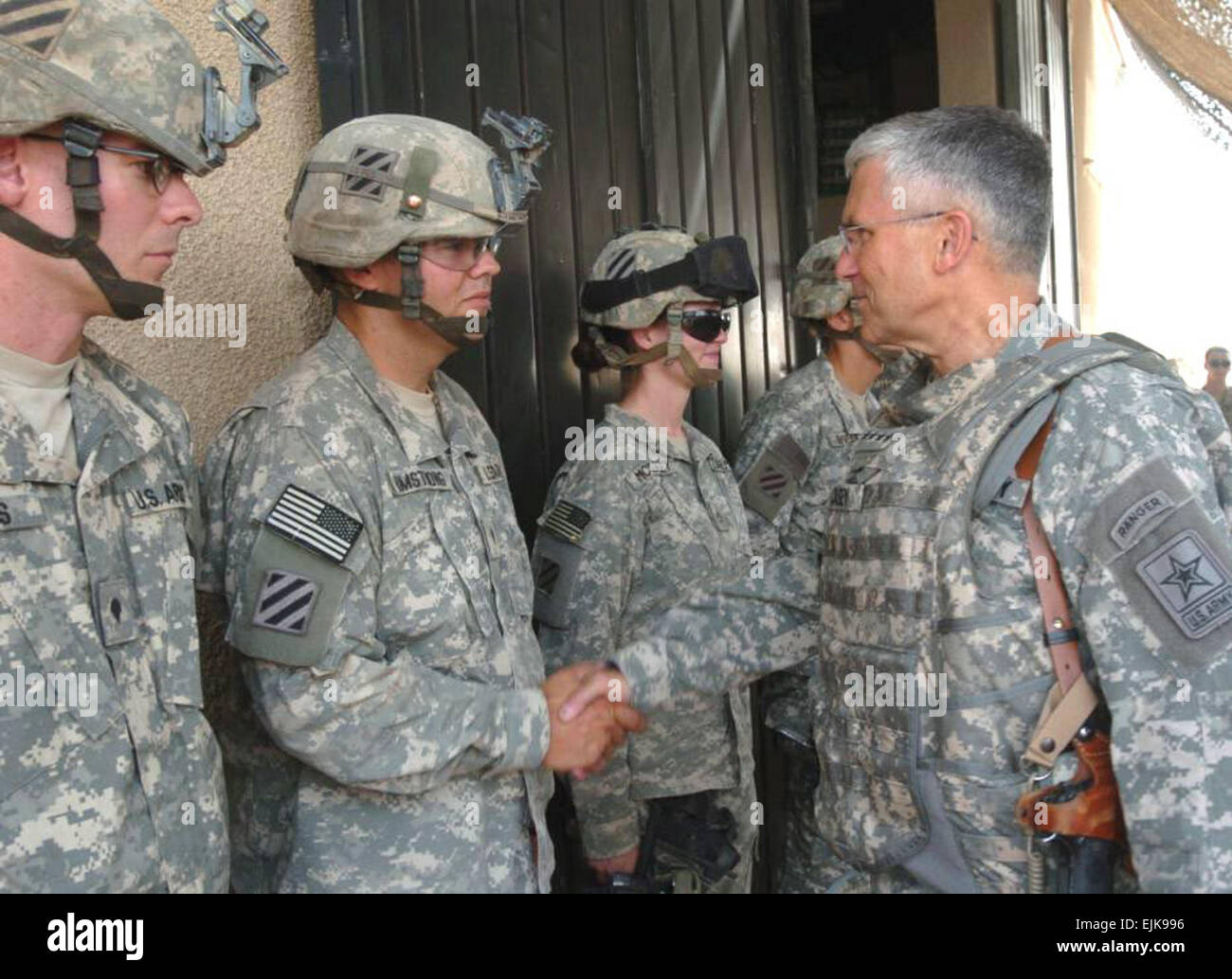 Army Chief of Staff Gen. George W. Casey Jr. presents Spc. Chris Armstrong, Headquarters Company, 1st Battalion, 15th Infantry Regiment, with a coin Aug. 11, at Patrol Base Assassin, Iraq. Gen. Casey visited Soldiers in Iraq and Afghanistan last week. Stock Photo