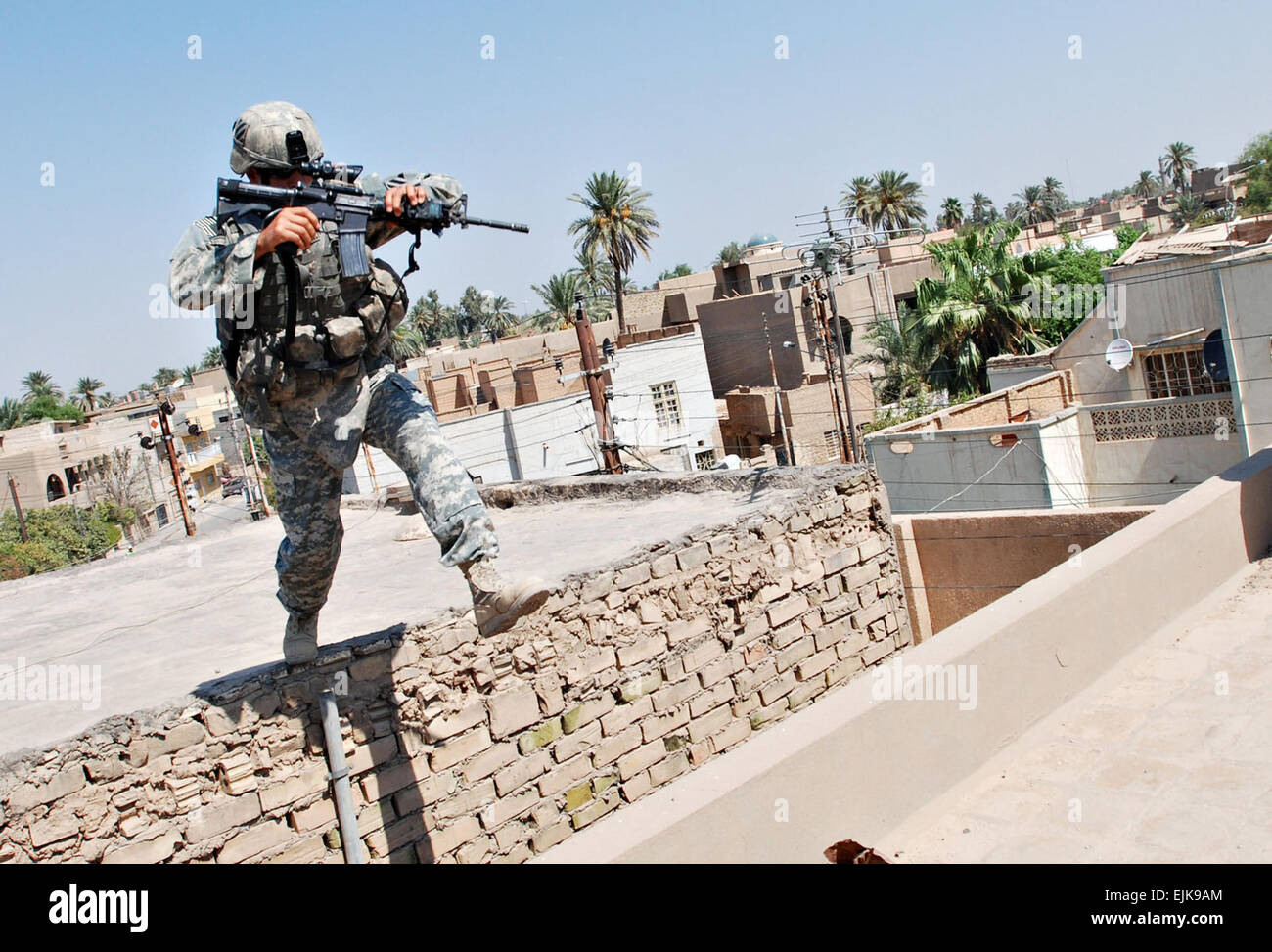 070822-A-5406P-009.JPG - Waterbury, Conn.-native Staff Sgt. Benjamin Concepcion, a squad leader with C Troop, 3rd Squadron, 7th Cavalry Regiment, 3rd Infantry Division out of Fort Stewart, Ga., traverses the gap between two rooftops while searching a building in Baghdad's Adhamiyah neighborhood Aug. 22.  Sgt. Mike Pryor, 2nd BCT, 82nd Abn. Div. Public Affairs Stock Photo