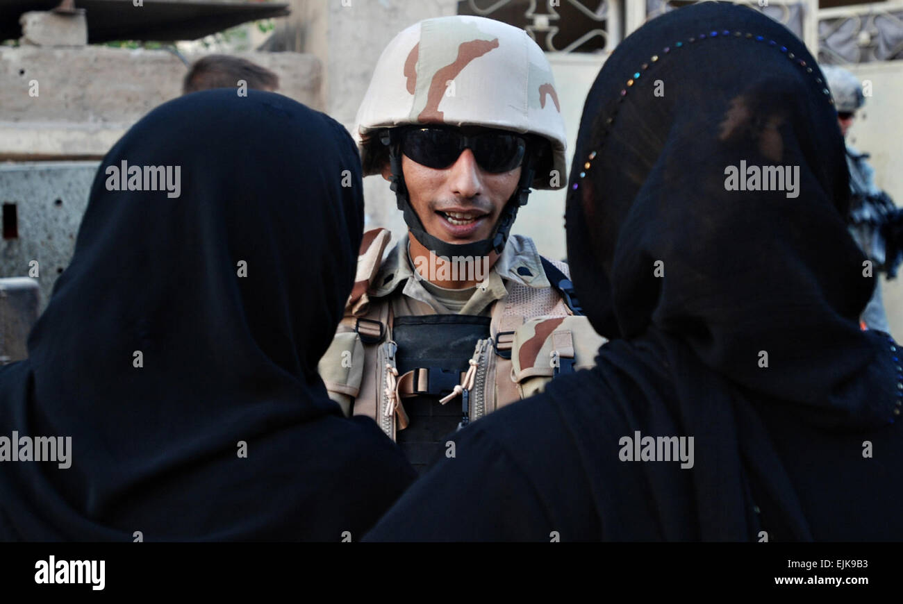 070905-A-5406P-023.JPG – Sgt. Yasser Ahmed, a soldier from the Iraqi Army’s 3rd Battalion, 1st Brigade, 11th Infantry Division, talks with local women during a patrol in the Graya’at area of Baghdad’s Adhamiyah District Sep. 5. Yasser is currently taking part in a program that embeds Iraqi Soldiers for two months with platoons from the 82nd Airborne Division’s 2nd Brigade Combat Team.  Sgt. Mike Pryor, 2nd BCT, 82nd Airborne Division Public Affairs Stock Photo