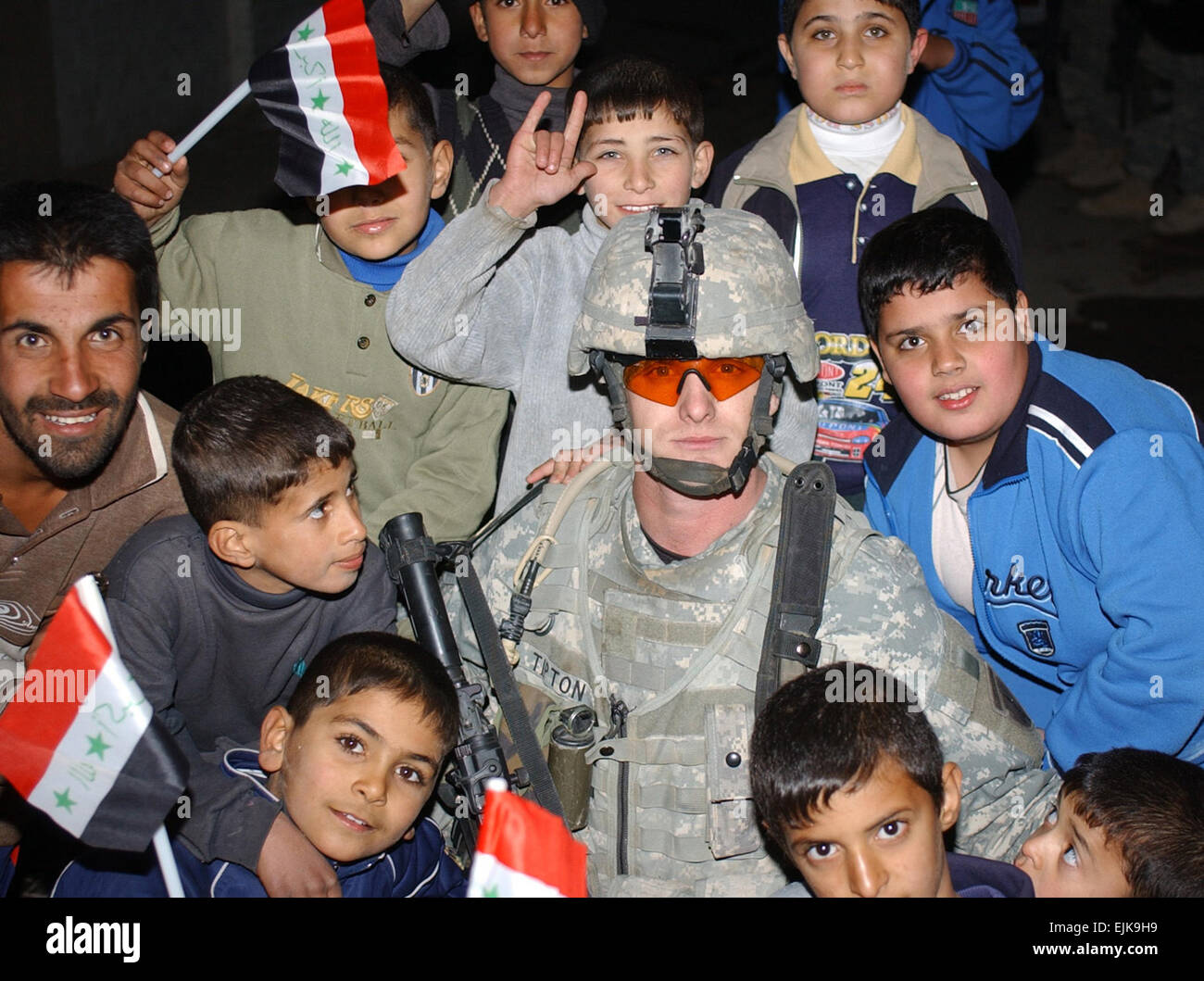 U.S. Army Spc. Chad Tipton, from 1st Squadron, 8th Cavalry Regiment, 2nd Brigade Combat Team, 2nd Infantry Division, poses for a photo with Iraqi children during a humanitarian operation in the Baladiat area of East Baghdad, Iraq, Jan. 7, 2008. U.S Army photo by Spc. Davis Pridgen Stock Photo