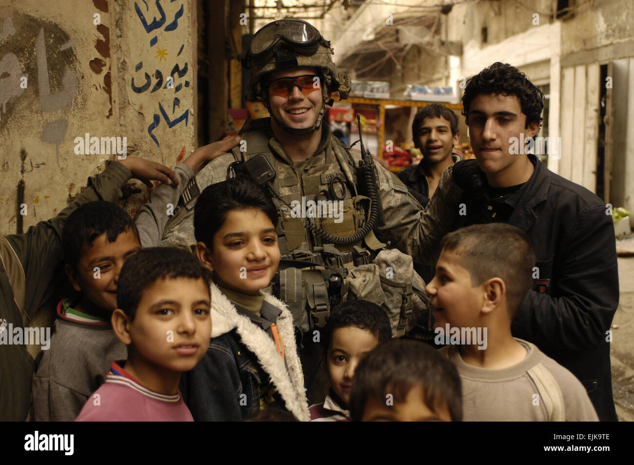 U.S. Army Sgt. Joseph Saladin, 3rd Platoon, Charlie Company, 1st Battalion, 504th Parachute Infantry Regiment, is swarmed by children during a patrol in Rusafa, Baghdad, Iraq, Feb. 18, 2008. Staff Sgt. Jason T. Bailey Stock Photo