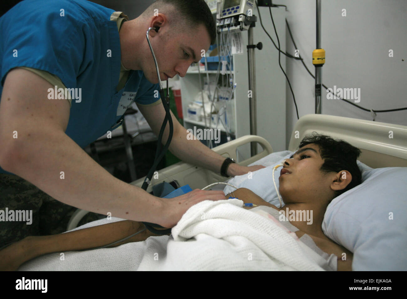 Sgt. Timothy L. Griswold, a staff nurse in the intensive care unit at the 325th Combat Support Hospital, Camp Al Asad, monitors Marwan Ahmad Mohammed’s vital signs before he goes in for his surgery. Griswold has been working with Marwan since he arrived at the hospital several days ago. Marwan’s brother has also been staying at the hospital to help the staff communicate with his brother and offer support. U.S. Marine Corps photo/Cpl. Tyler B. Barstow Stock Photo