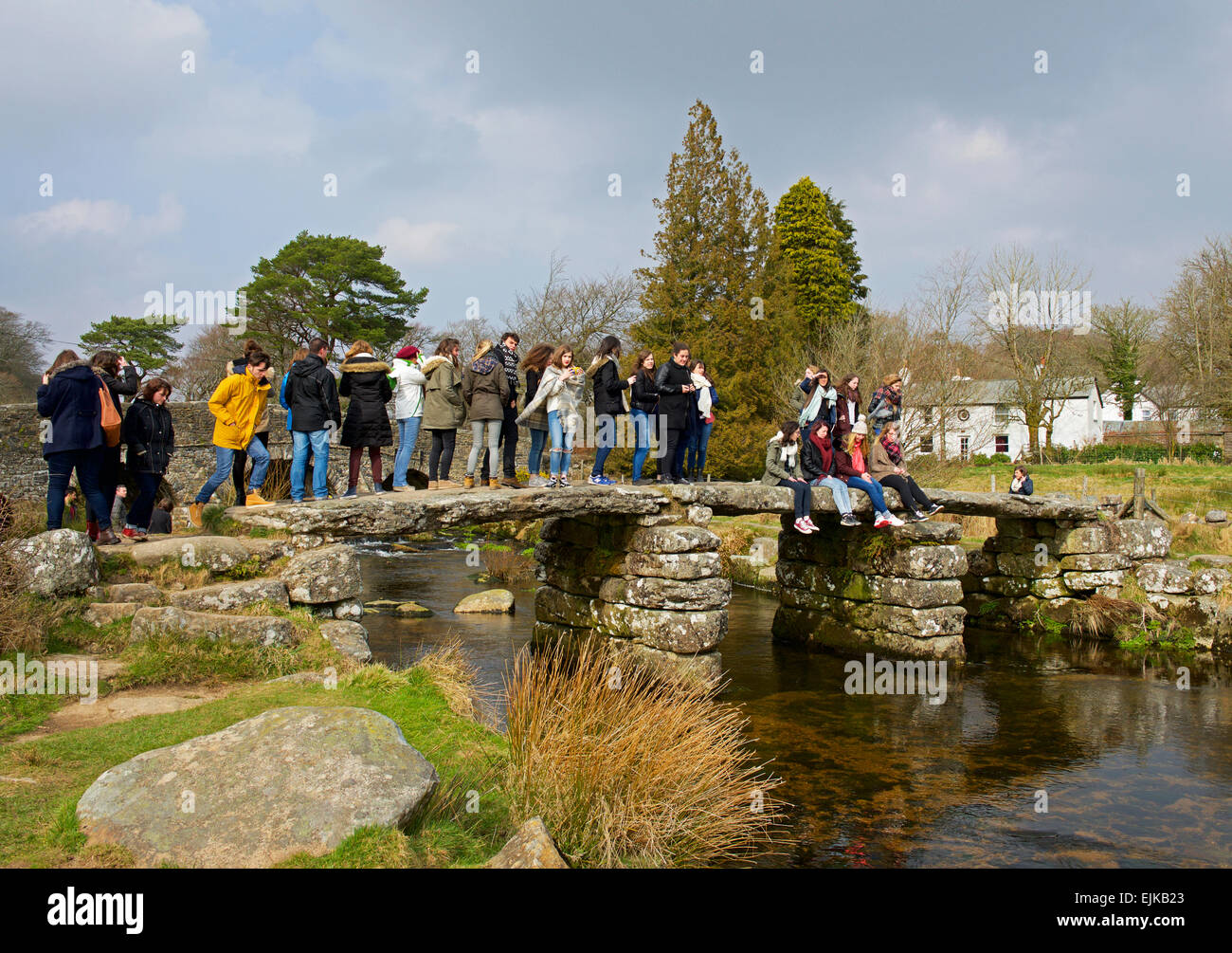 Lots of people crowding onto the old clapper bridge, at Postbridge, Dartmoor National Park, Devon, England UK Stock Photo