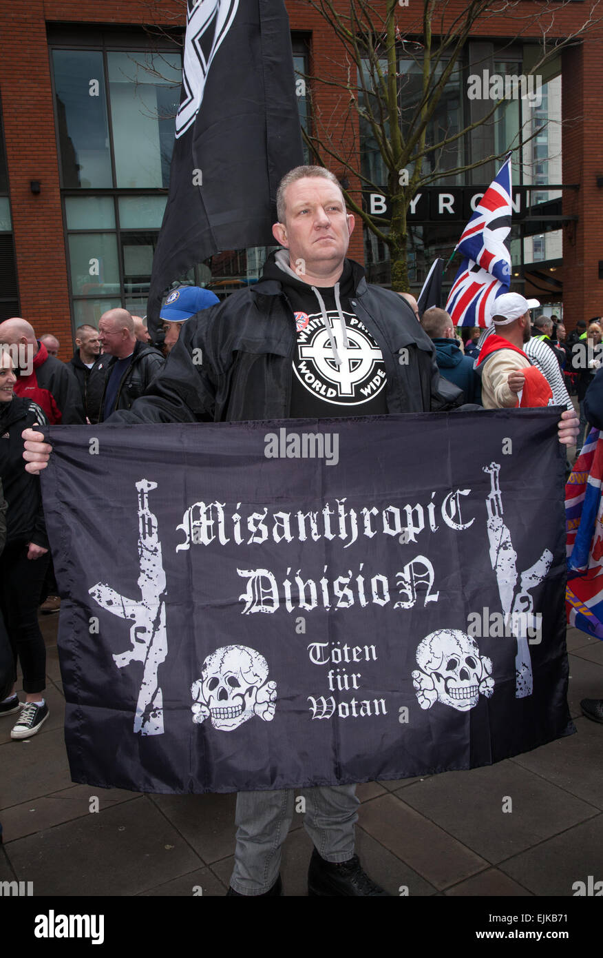 Manchester, UK 28th March, 2015. Far right demonstrators with flags & banners at the National Front and White Pride Demo in Piccadilly.  Arrests were made as Far Right 'White Pride' group gathered in Manchester to stage a demonstration when about 50 members of the group waved flags and marched through Piccadilly Gardens. Anti-fascist campaigners staged a counter-demonstration and police line separated the two sides. Greater Manchester Police said two arrests were made, one for a breach of the peace. The second was also held for a public order offence. Stock Photo