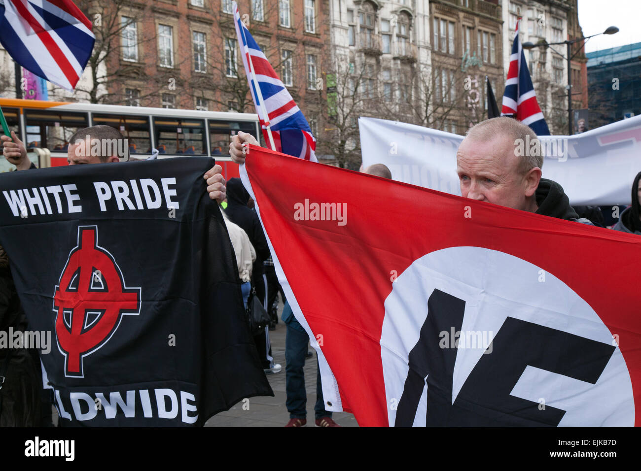 Far right demonstrators with flags & banners at the National Front and White Pride Demo in Piccadilly.  Manchester, UK March, 2015. Arrests were made as Far Right 'White Pride' group gathered in Manchester to stage a demonstration when about 50 members of the group waved flags and marched through Piccadilly Gardens. Anti-fascist campaigners staged a counter-demonstration and police line separated the two sides. Greater Manchester Police said two arrests were made, one for a breach of the peace. The second was also held for a public order offence. Stock Photo