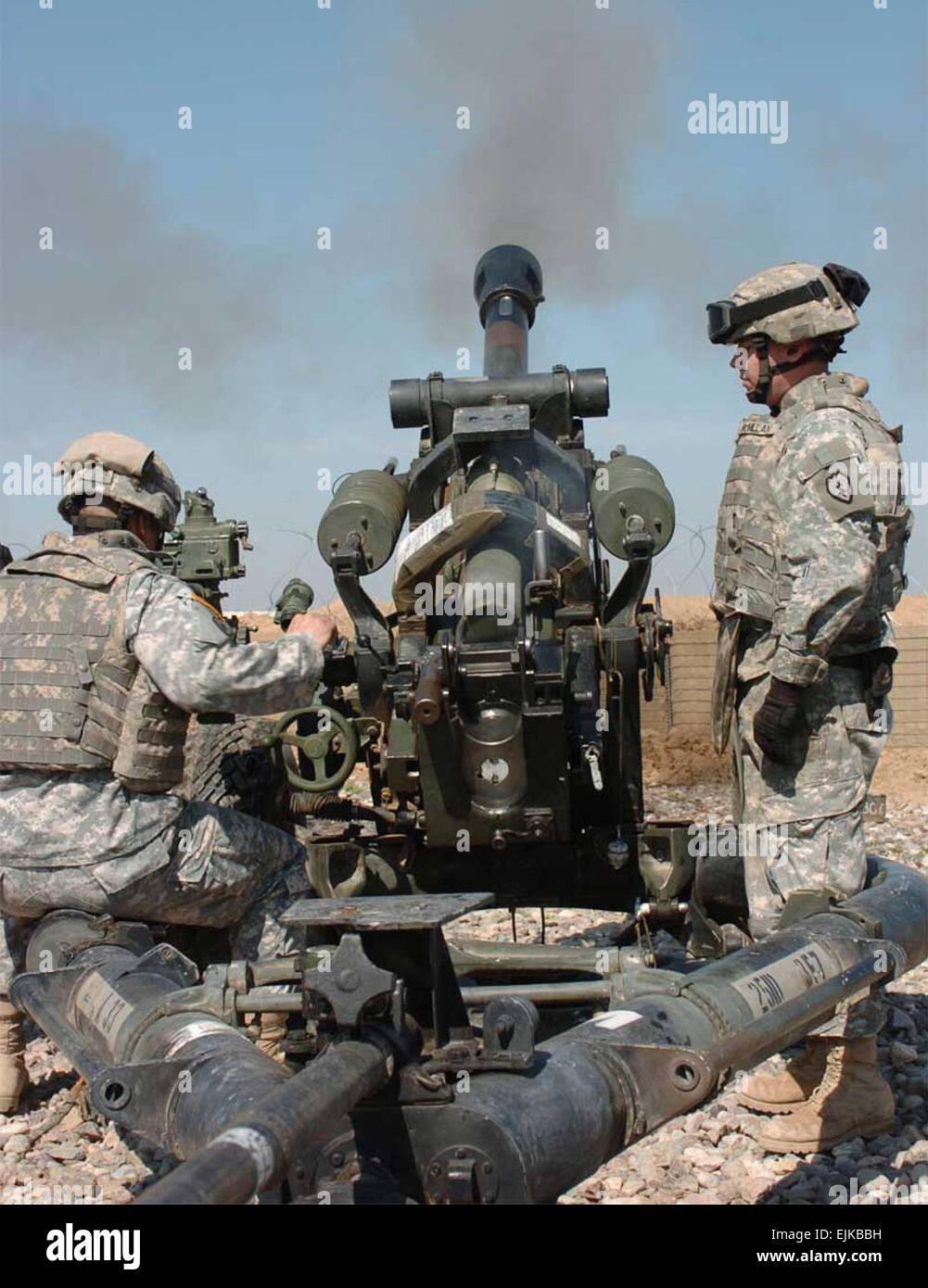 Spc. Christopher Flores left, a gunner, and Pfc. Chealse McMillian right, an assistant gunner, both with A Battery, 3rd Battalion, 7th Field Artillery Regiment, fire a Howitzer during a live-fire exercise at Forward Operating Base McHenry. Stock Photo