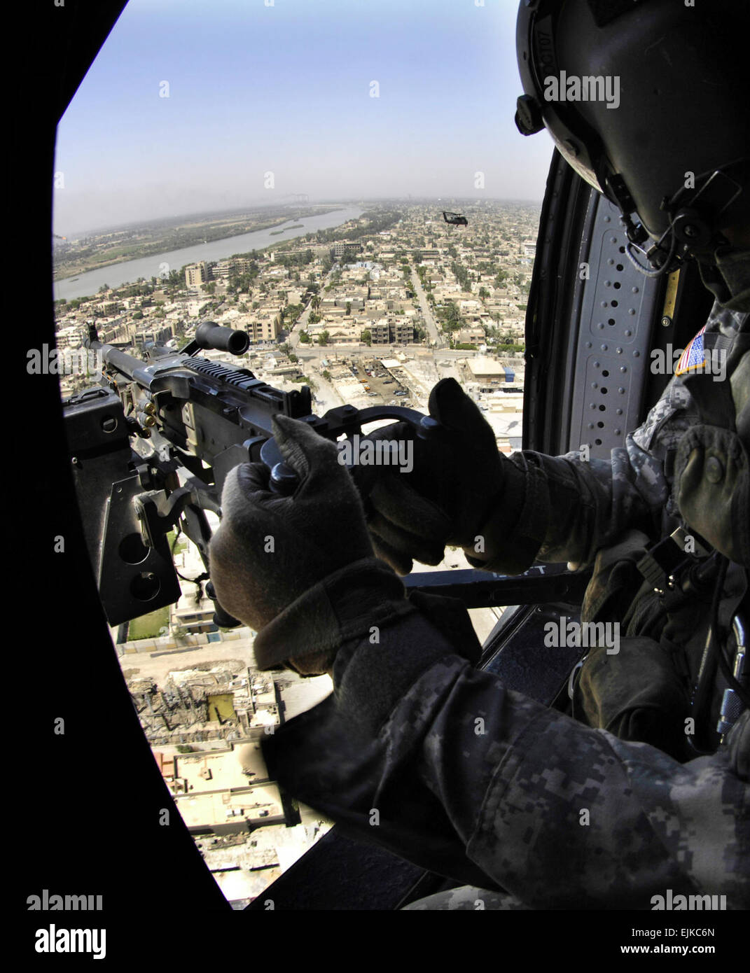 A UH-60 helicopter door gunner provides security as helicopters fly over Baghdad, Iraq, June 16, 2007.   Cherie A. Thurlby. Stock Photo