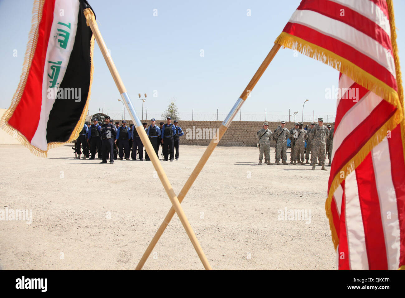 U.S. Soldiers from 1st Battalion, 38th Infantry Regiment, 4th Stryker Brigade, 2nd Infantry Division and Iraqi Police salute the U.S. flag during a ceremony at Joint Coordination Center Abu Ghraib in Baghdad, Iraq, April 20. The ceremony was held to establish the transfer of JCC Abu Ghraib from a joint operation to Iraqi police control. Stock Photo