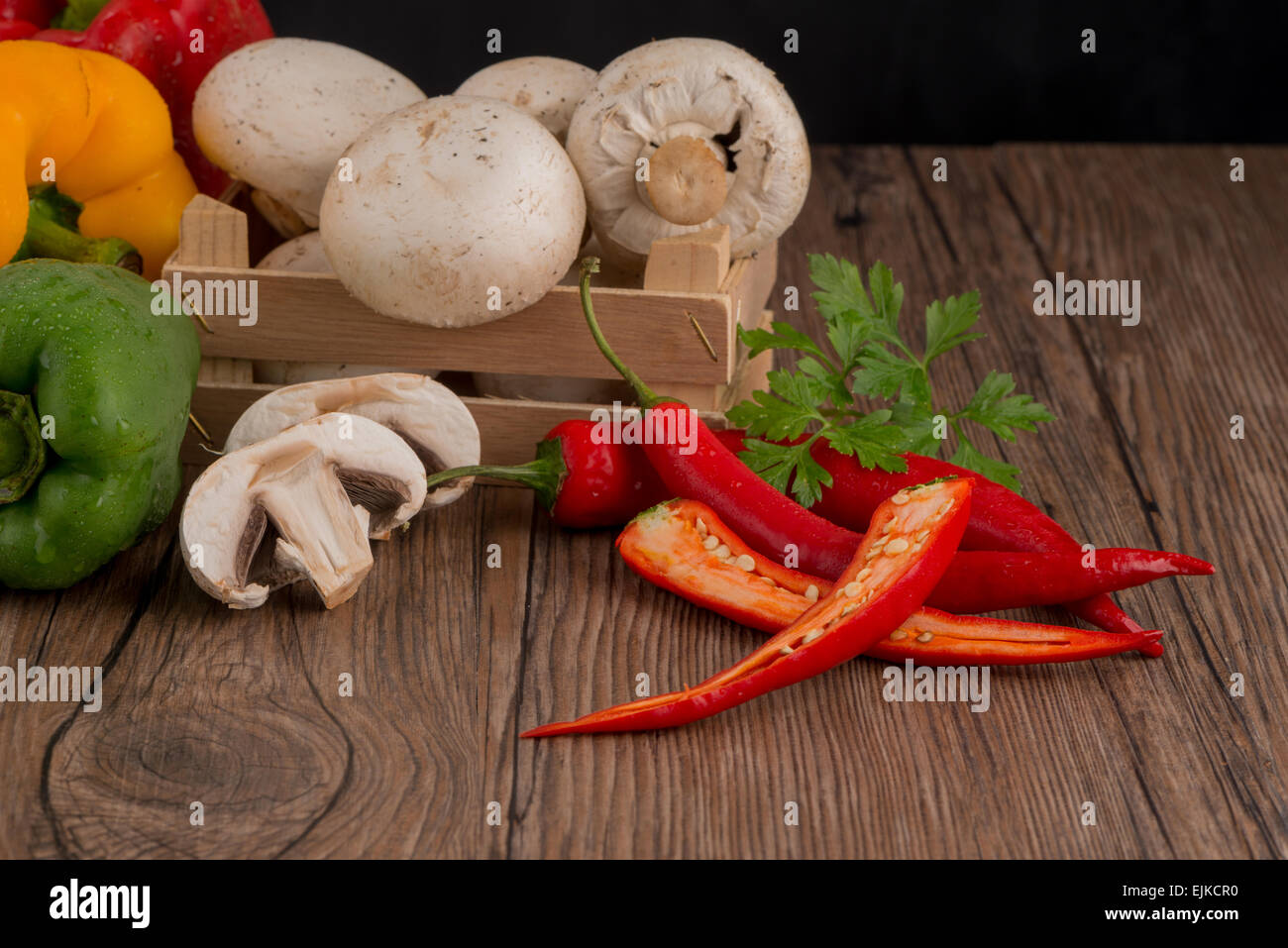 Colored bell peppers on old wooden table Stock Photo - Alamy