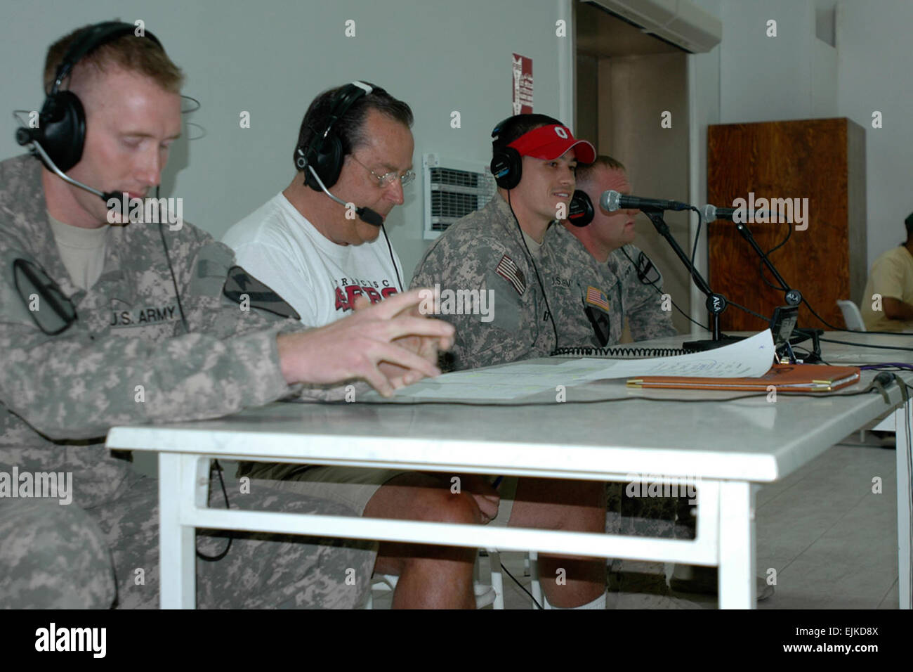 2nd Lt. Charlie Rockwood with Headquarters Troop, 1st Cavalry Division, Capt. Josh Holden with 2nd Battalion, 82nd Field Artillery Regiment, and Sgt. Patrick Miller, with 1st Battalion 12th Cavalry Regiment participate in a live radio broadcast with sports talk radio host Ron Barr second from left. The syndicated national U.S. sports talk show, Sports Byline, was broadcast from the Forward Operating Base Marez dining facility July 14.          Sports Byline radio show comes to Mosul  /-news/2009/07/15/24429-sports-byline-radio-show-comes-to-mosul/?ref=home-headline-title6 Stock Photo