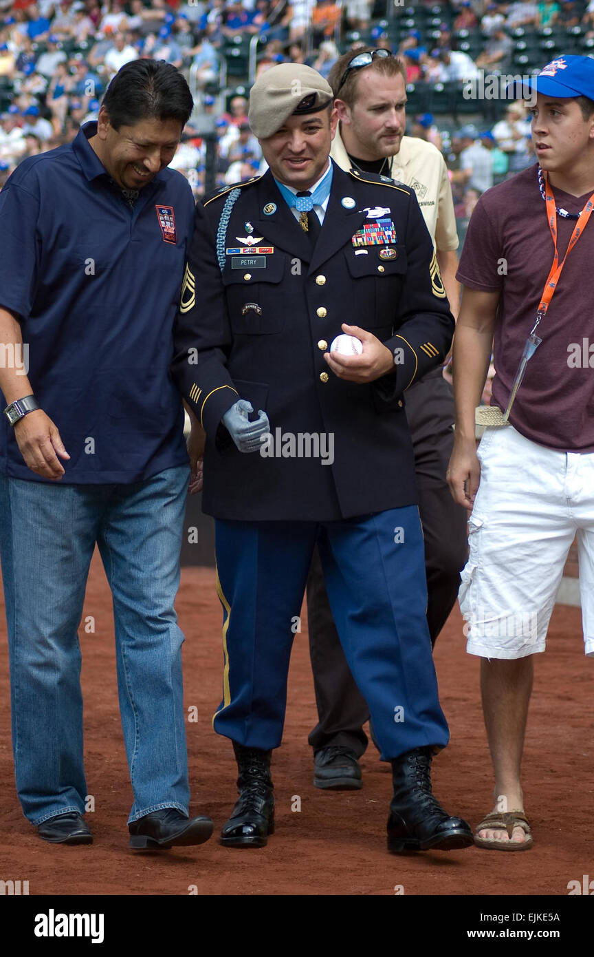 Sgt. 1st Class Leroy A. Petry, 75th Ranger Regiment Medal of Honor recipient, speaks with former New York Mets pitcher Jesse Orosco, prior to the game between the NY Mets and Philadelphia Phillies at Citi Field, July 16. Petry met with players and coaches, prior to the game and received a standing ovation from the fans during the third inning.  Sgt. 1st Class Michael R. Noggle, USASOC Public Affairs/medalofhonor/petry/ Stock Photo