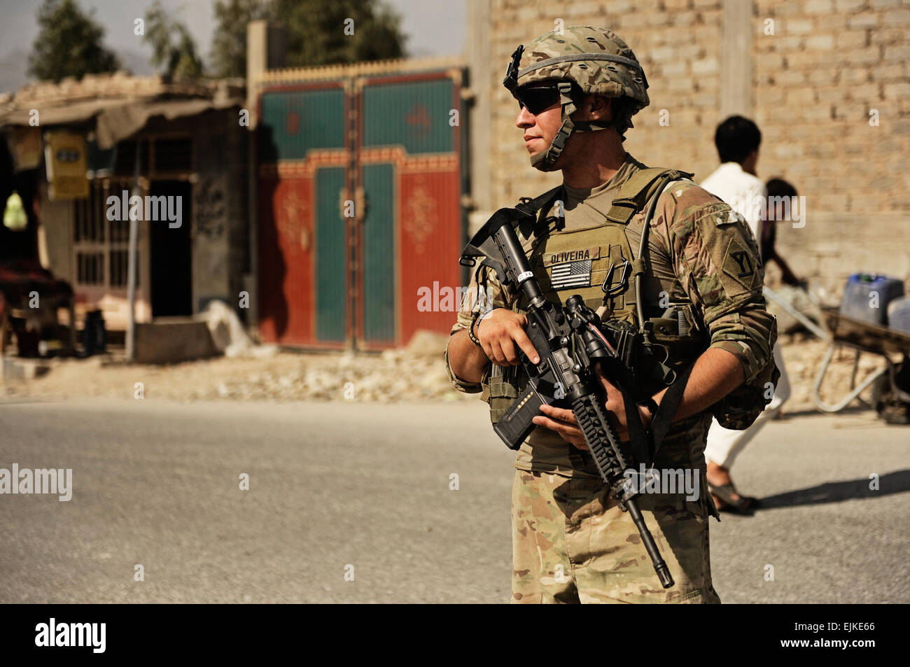 U.S. Army Spc. Alexander Oliveira, rifleman attached to Laghman Provincial Reconstruction Team, pulls security at an intersection while Afghan Uniformed Police lead the way on a joint patrol in Mehtar Lam district, Laghman province, Sept. 26. The Police Transition Assistance Team attached to the PRT is responsible for the training and mentorship of the local Afghan police and routinely conducts training with side by side with them. Stock Photo