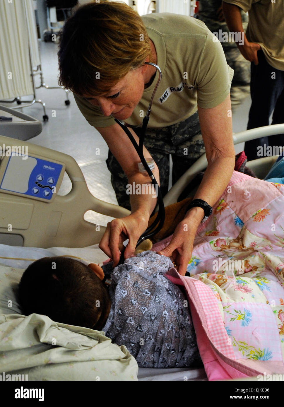 U.S. Army Maj. Una Alderman, the chief nurse officer for the 452nd Army Reserve, from Wisconsin, tends to a patient at the hospital on Forward Operating Base Salerno, Aug. 5, 2009. She is stationed in the same area of operation as her son, Staff Sgt. Seth Alderman, a military policeman with the 4th Brigade Combat Team, 25th Infantry Division.    U.S. Army Pfc. Andrya Hill, 4th Brigade Combat Team, 25th Infantry Division Public Affairs Office         Mother, son serve together in Afghanistan  /-news/2009/08/08/25668-mother-son-serve-together-in-afghanistan/index.html Stock Photo