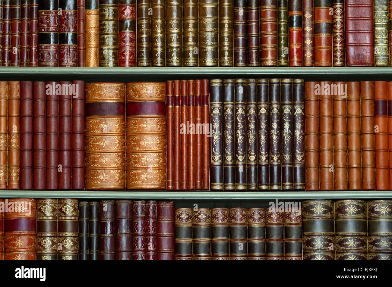 Old library of vintage hard cover books on shelves Stock Photo