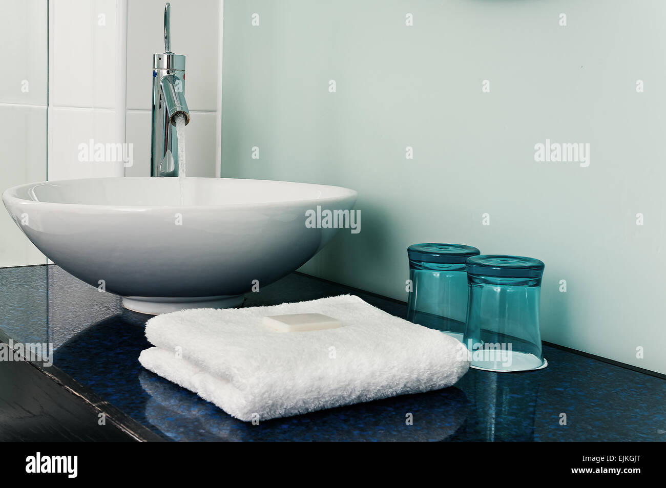 Bathroom sink counter towels water glass blue Stock Photo