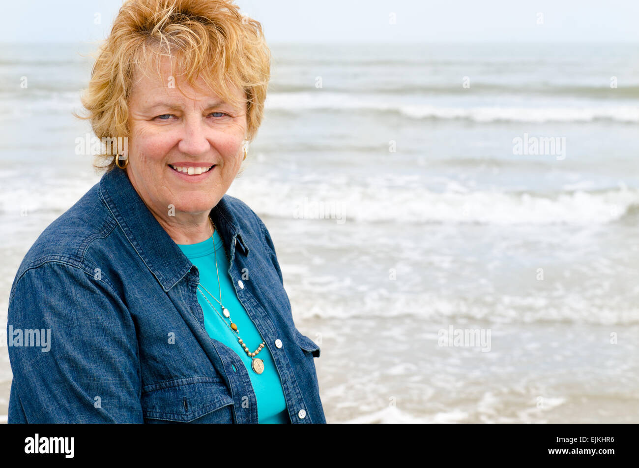 Senior woman on the beach smiling Stock Photo