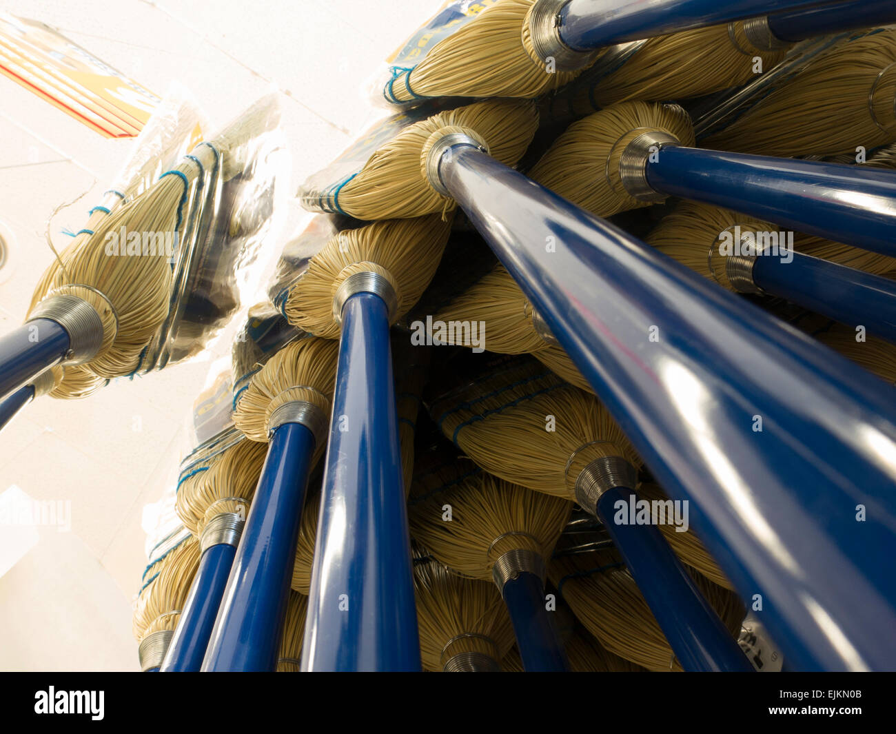 Looking up at a display of brooms in a supermarket. Stock Photo