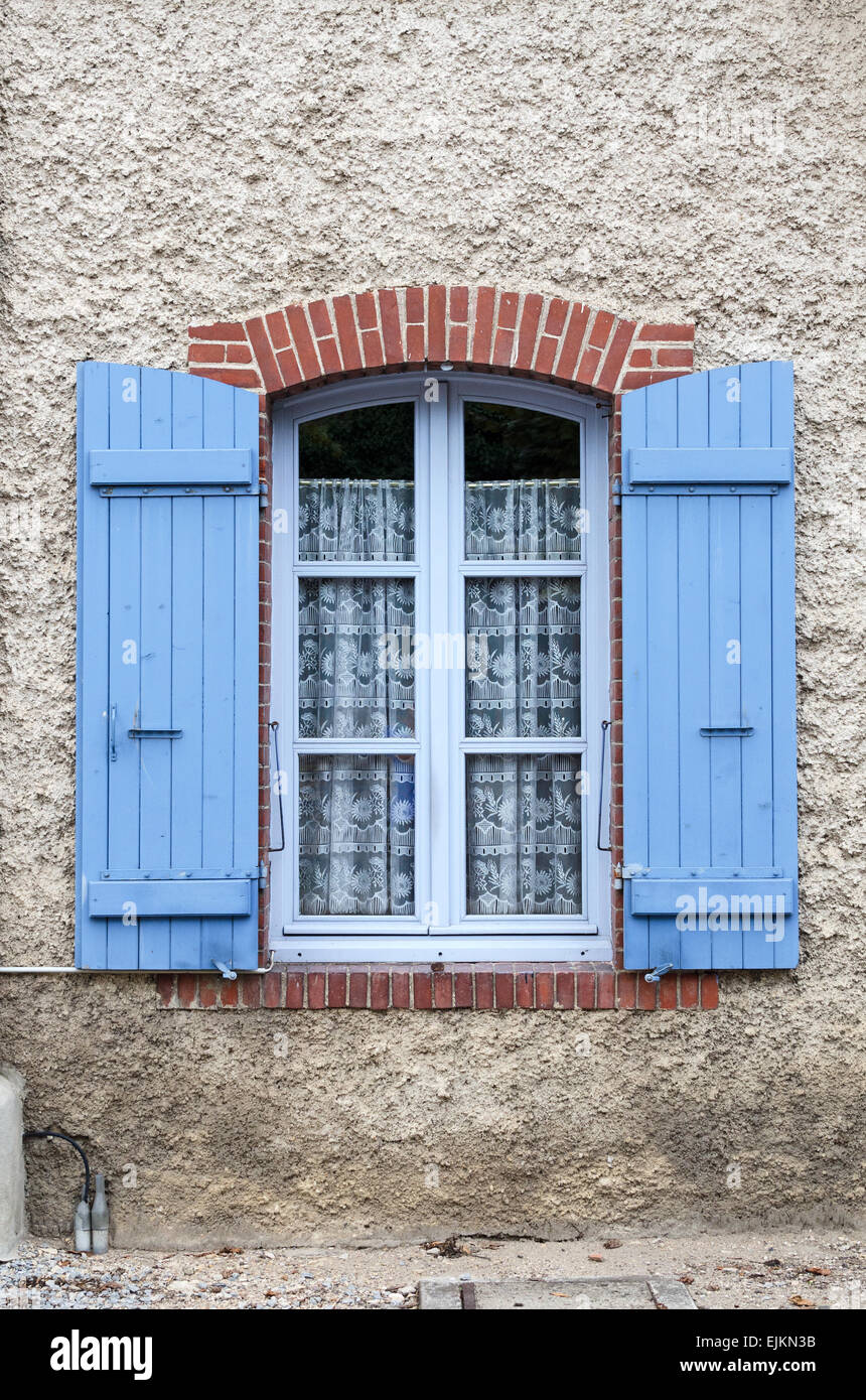 Lace curtains screen a charming arched window in the town of Chagny, Saone et Loire, Burgundy, France. Stock Photo