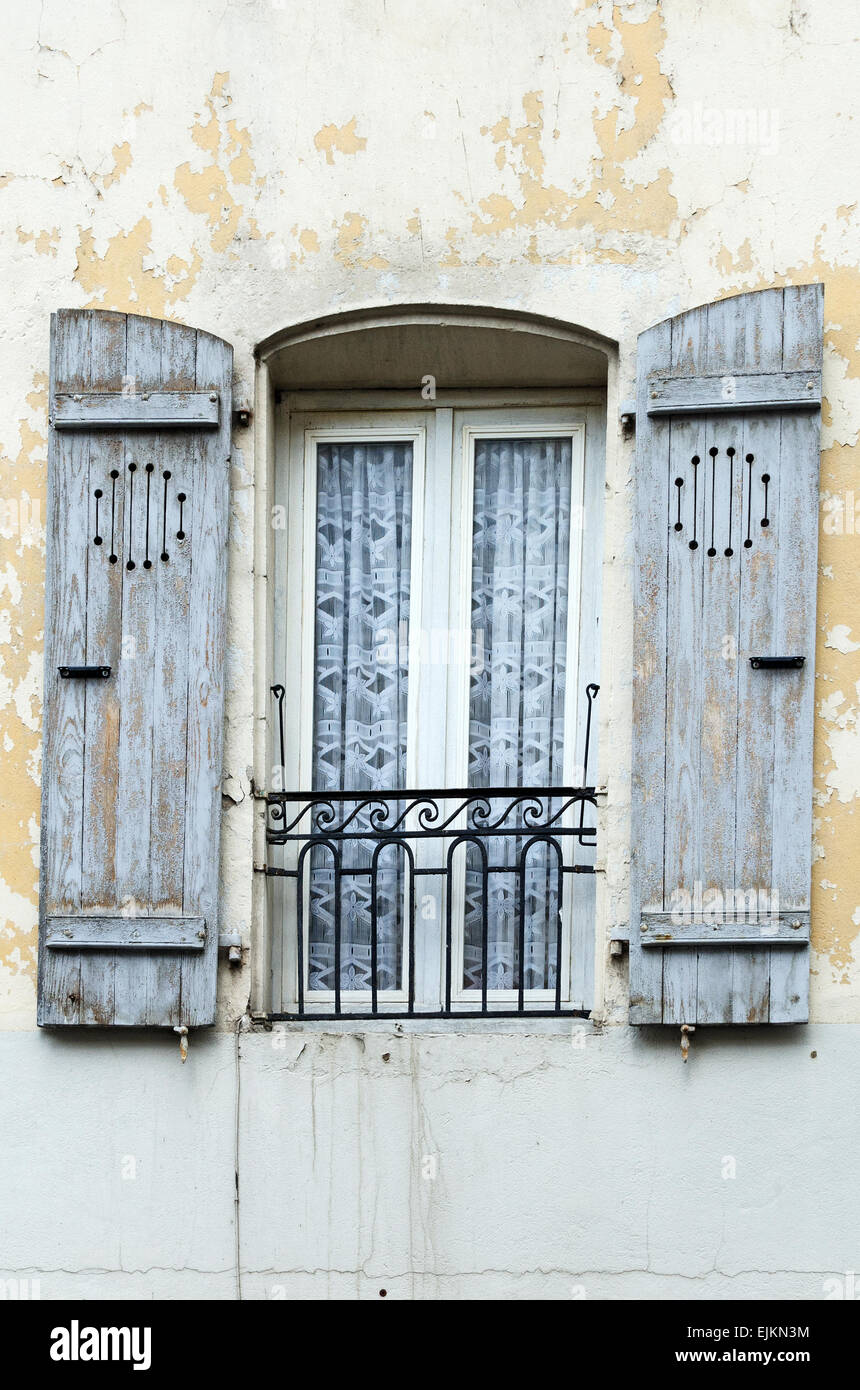 Grey-blue paint peeling off wooden shutters on an old building in Chagny, Burgundy, France. Stock Photo