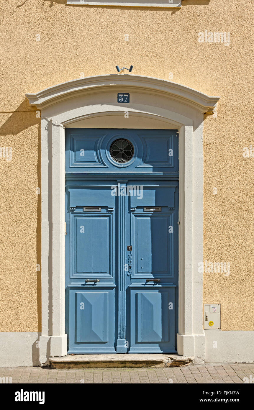 Paneled blue doors to a yellow plastered house in the town of Chagny, Saone et Loire, Burgundy, France. Stock Photo